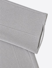 Detalle del bajo del pantalón gris con tira pasante de tejido para el pie, mostrando el diseño funcional del bajo oversize.