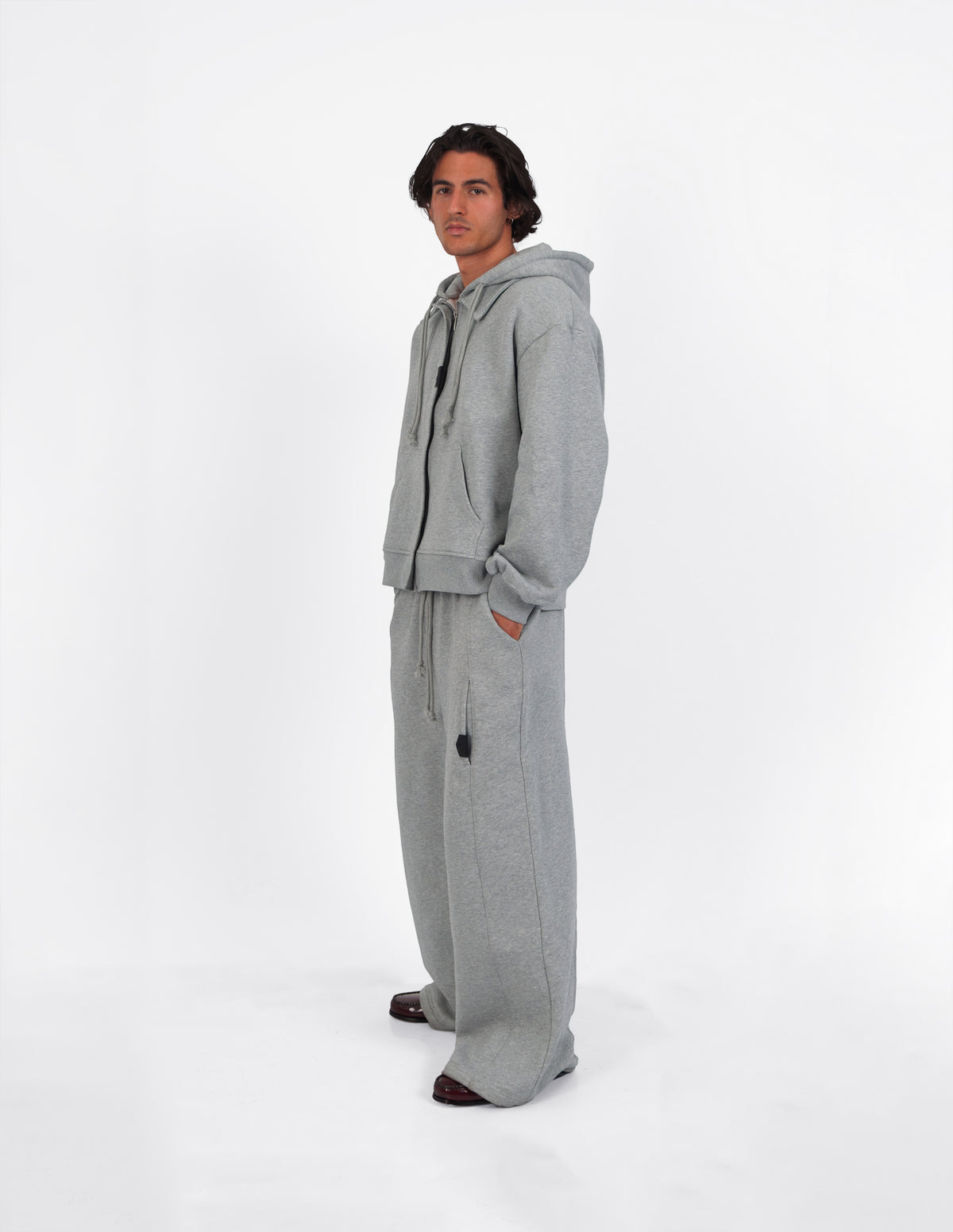 Pantalón gris de corte amplio, con cuatro bolsillos, visto de cuerpo entero.