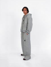 Pantalón gris de corte amplio, con cuatro bolsillos, visto de cuerpo entero.