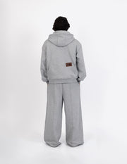 Vista trasera del pantalón de chándal gris de diseño urbano y contemporáneo, destacando la silueta holgada de la prenda.