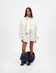 Camisa blanca oversize de algodón 100% con corbata integrada en modelo  chica vista frontal.