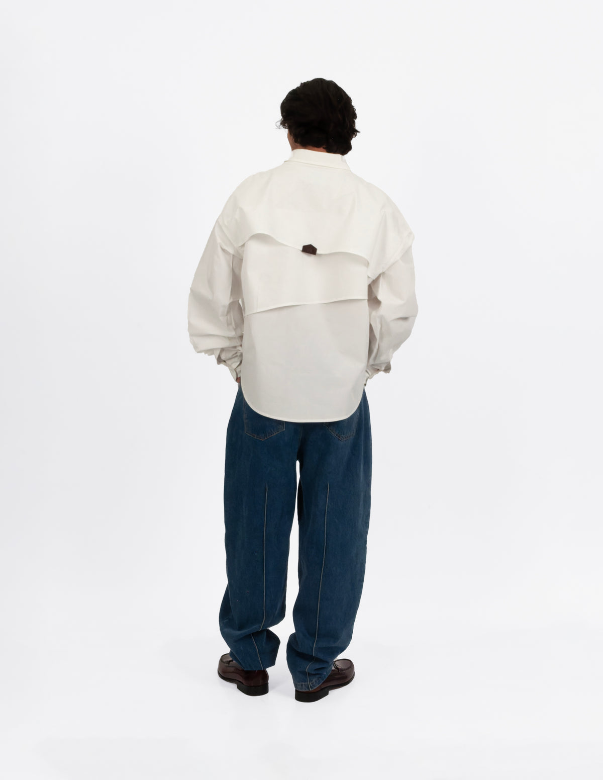 Camisa oversize blanca de algodón en hombre, vista de espalda con canesú posterior.