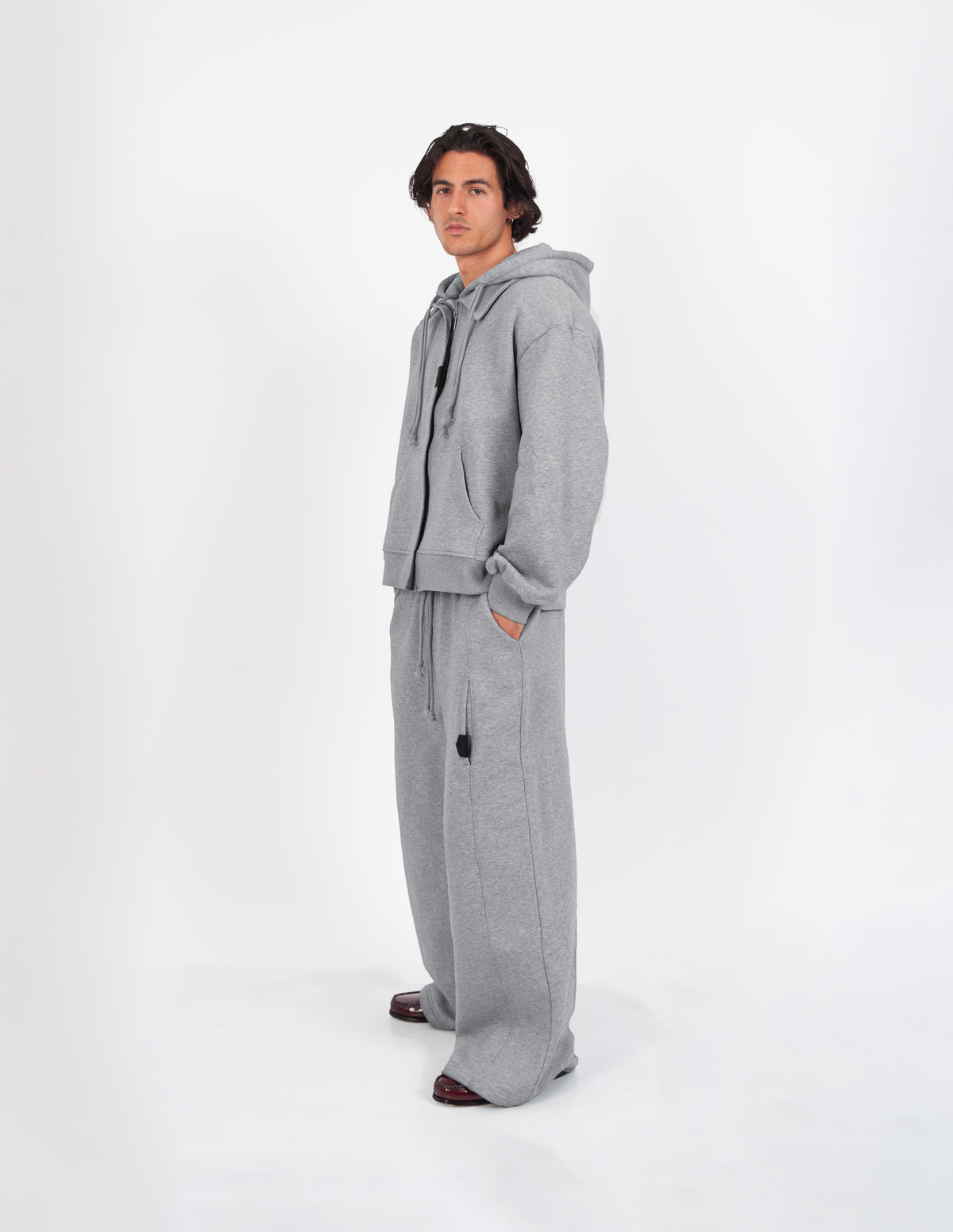Sudadera oversize unisex gris de WAENN vista de perfil, con capucha y pantalón a juego